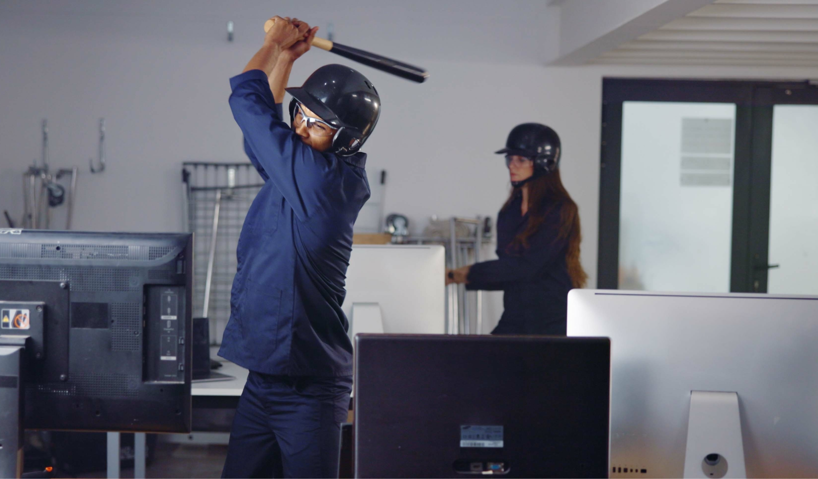 A man swinging a bat in a rage room